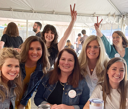 Group shot of smiling WCG team members seated at an outdoor table